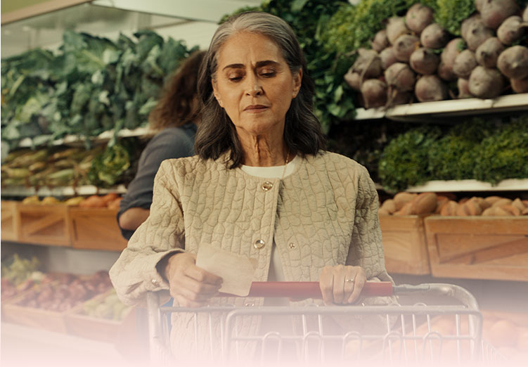 Mujer comprando en el supermercado empujando un carrito